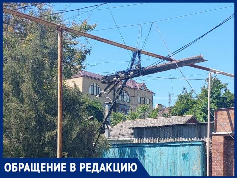 На одной из улиц Таганрога аварийный столб висит на проводах несколько дней